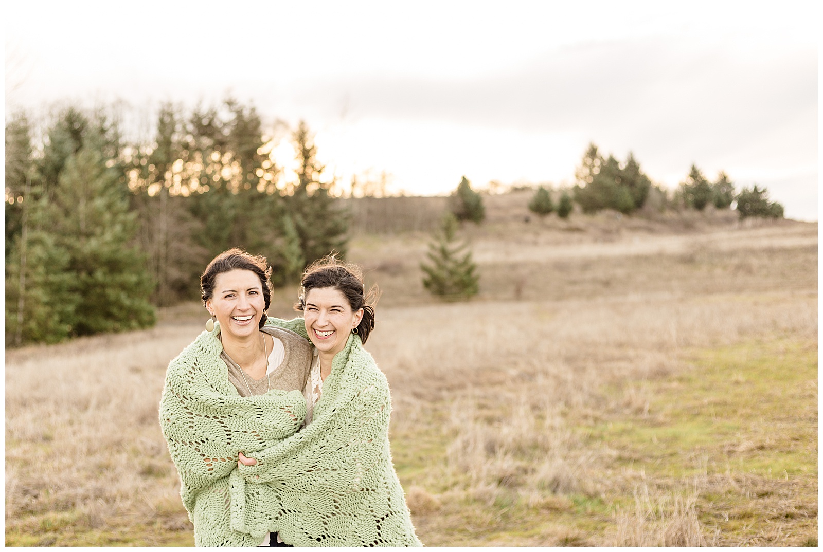 Sisters in their 20's wrapped in blanket out in nature