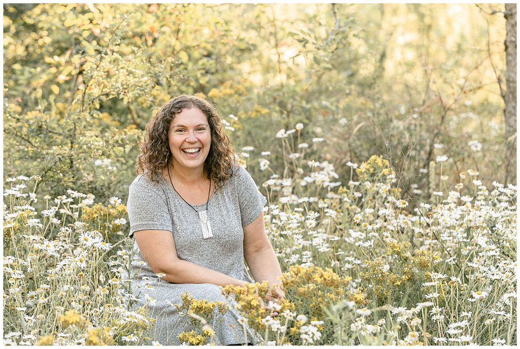 Portland Oregon Midwife, Mirra Nerenberg, sitting in a field of flowers