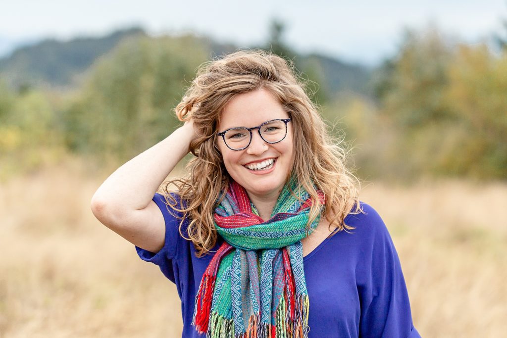 Woman in nature with a bright blue shirt and colorful scarf out in nature for headshot portraits