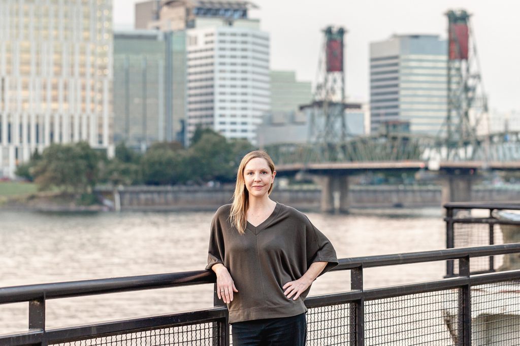 Light-skinned woman standing in front of Portland cityscape - fertility acupuncturist