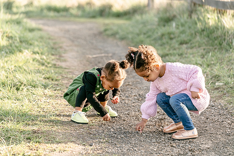 Two toddlers sporting their Ozznek Shoes while picking up rocks on a trail