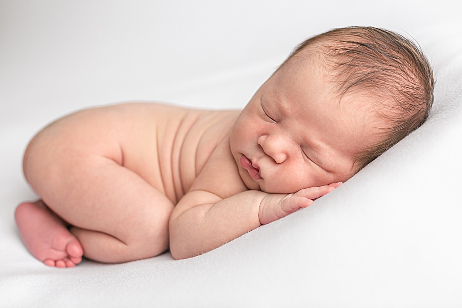 newborn laying in a cute baby pose at a portland oregon newborn photography studio
