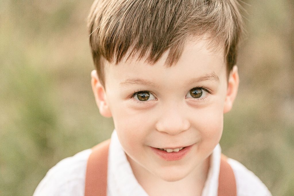 Little boy staring into camera during outdoor family photo session.