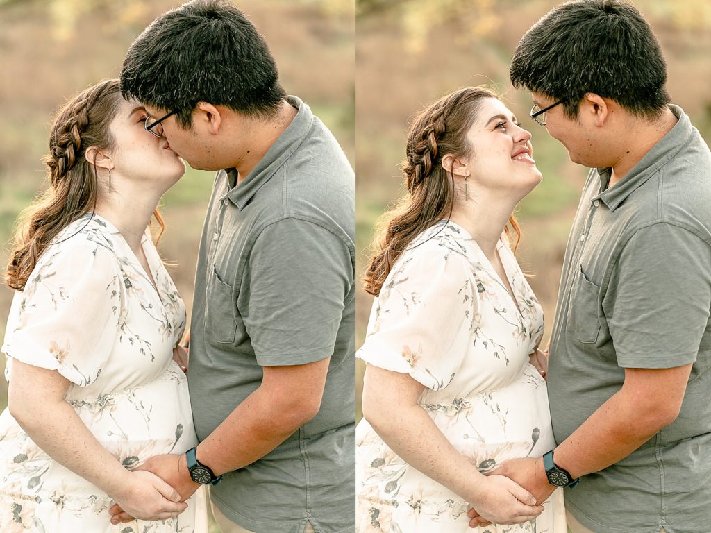 Pregnant woman in white floral dress kissing husband in light sage green shirt during maternity photo session