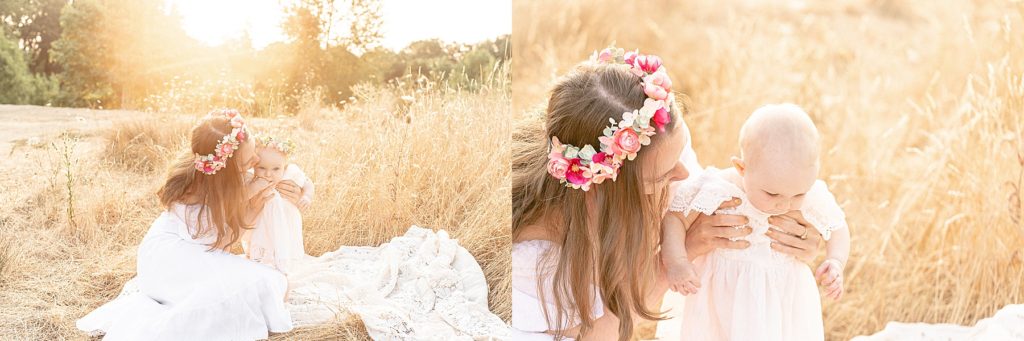 light-skinned Mother and daughter in white dresses and flower crowns in a field of long golden grasses at sunrise during a summer outdoor family photo session