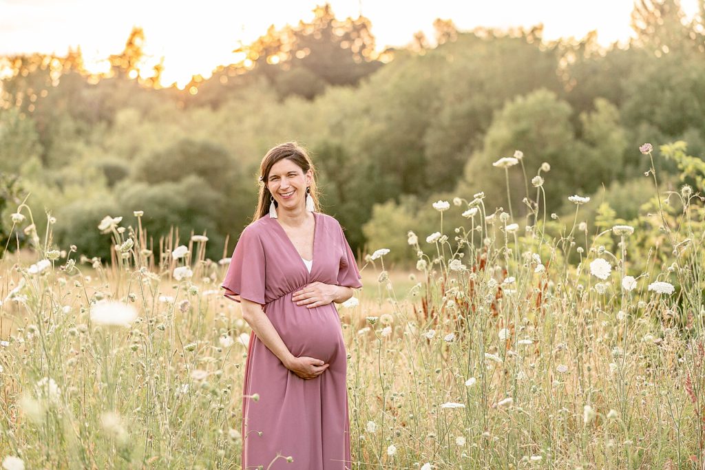 pregnant woman getting maternity portraits done out in nature