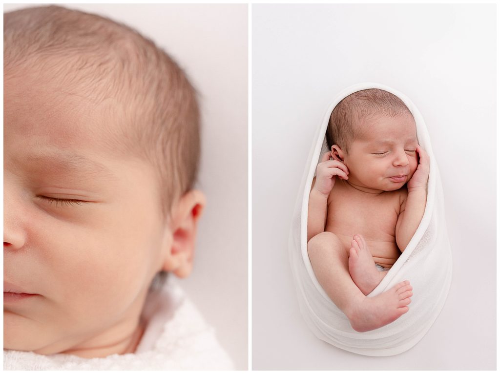 Light-skinned baby wrapped in white on white backdrop at newborn photography session.