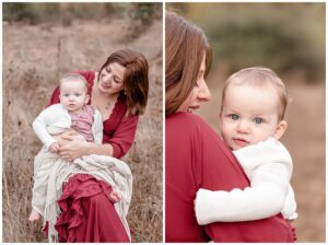 Mom in mauve dress holding baby girl dressed in pink dress with white sweater. Outdoors in a field of tall golden grasses at Portland family photography session.