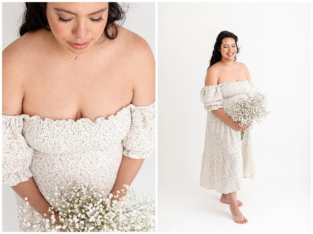 Pregnant woman in light floral neutral off-the-shoulder gown holding a bouquet of baby's breath at her maternity photo session.