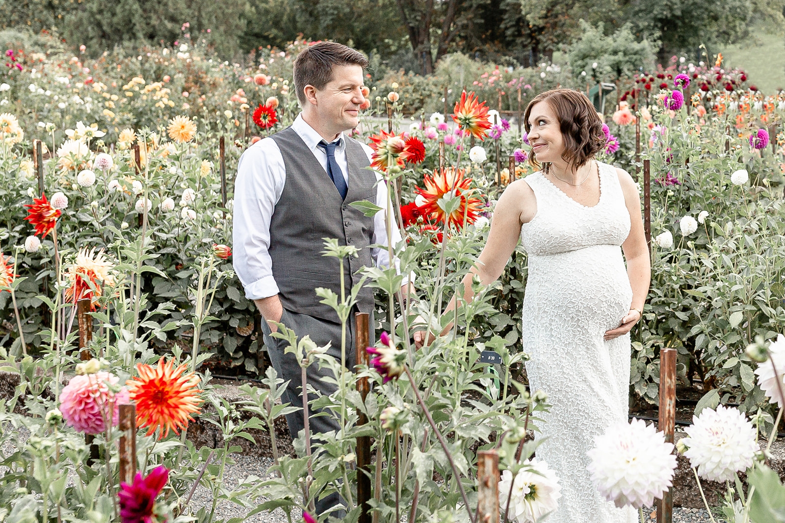 A mother to be leads her husband by the hand through a large flower garden Portland Date Night Ideas
