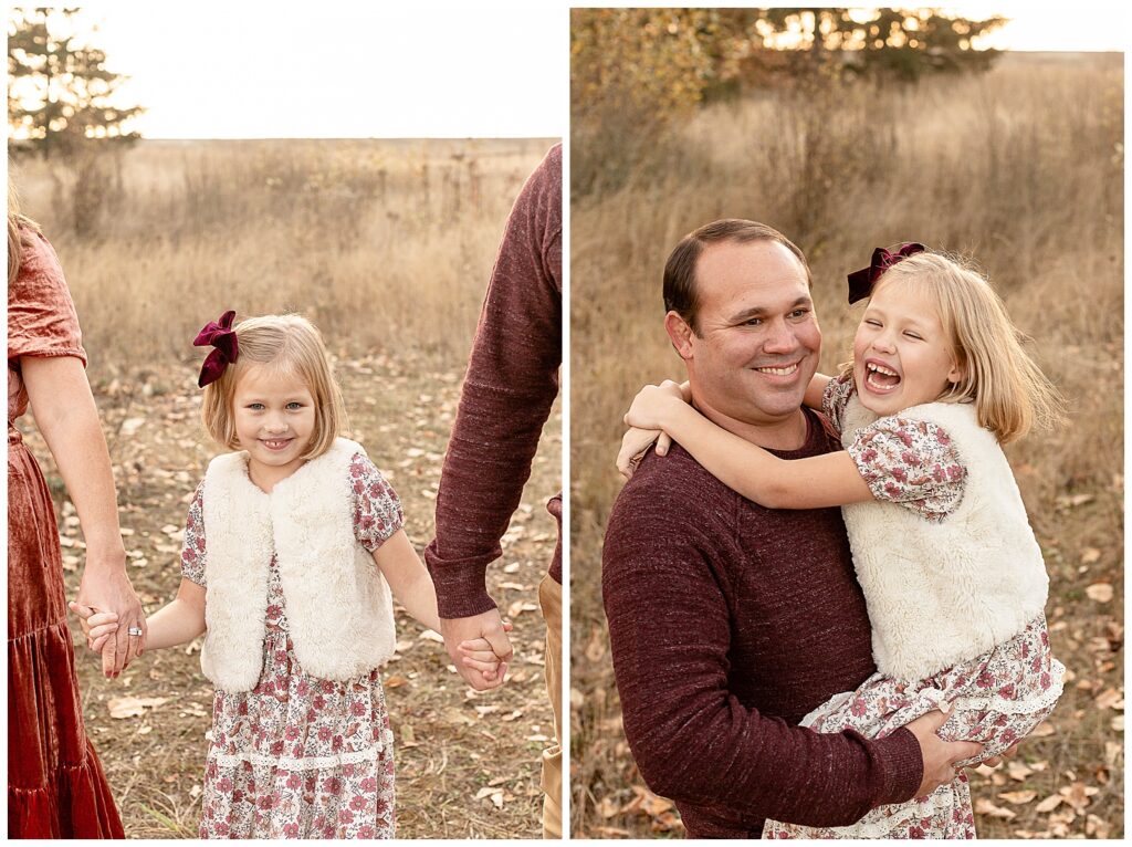 7 year old girl dressed in a floral dress of burgundy and cream and wearing a little cream faux fur vest with a burgundy bow in her hair. The image on the left she is the focus of the image and holding both of her parents hands on either side. The image on the left includes her father who is holder her and they are laughing together. 