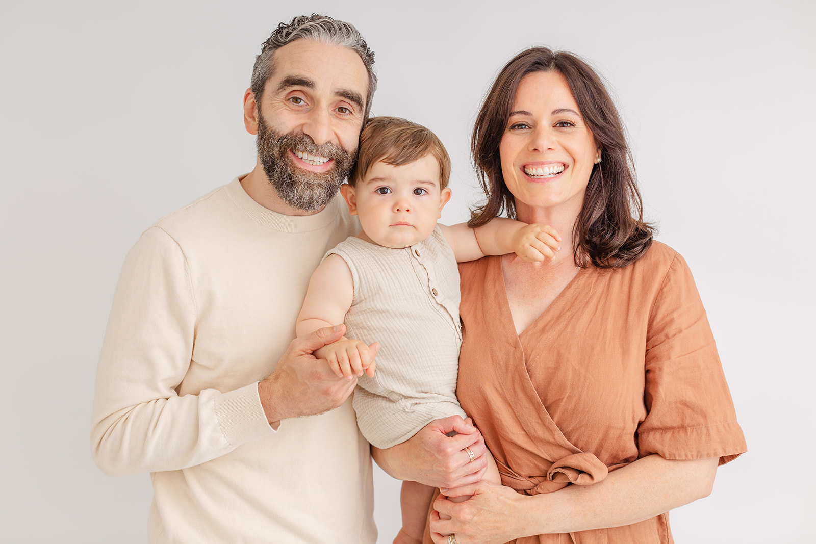 Professional family milestone photography session in Portland OR with parents holding young child naturally
