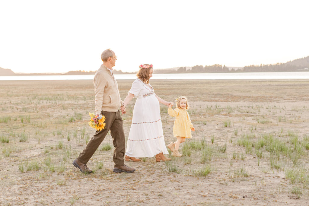 Parents and children walking through a scenic Portland field at sunset