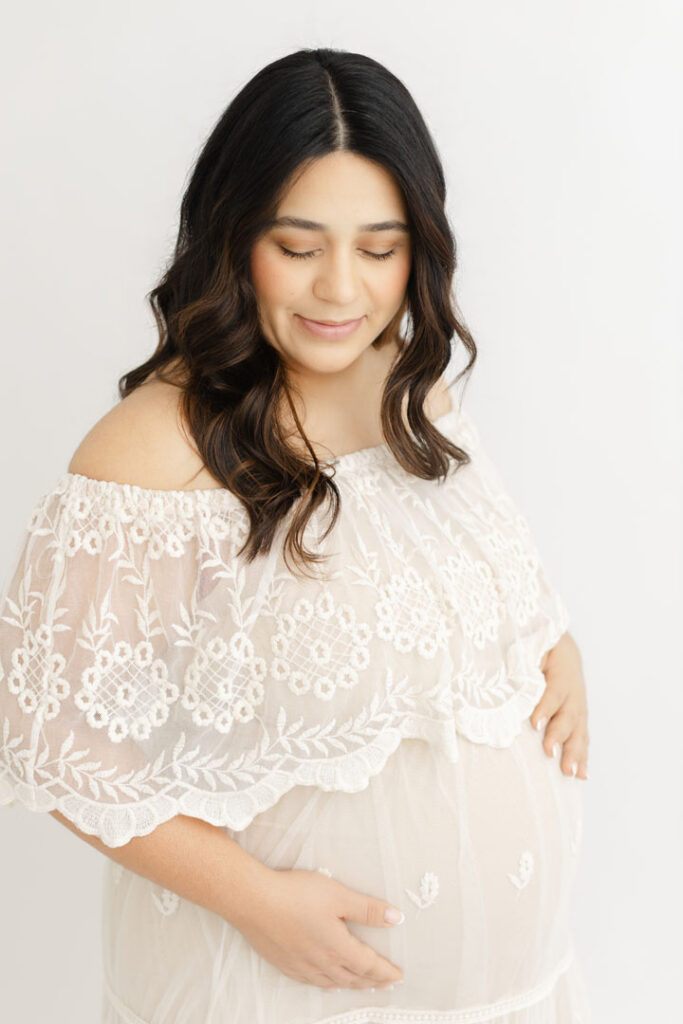 Mother-to-be posing with her baby bump during a natural light maternity session